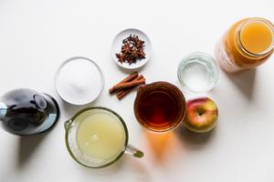 ingredients for spiced bourbon punch in small bowls and jars