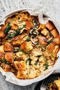spinach mushroom strata in a parchment lined baking pan