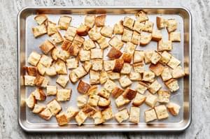 toasted cubed bread on a baking sheet
