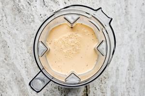 eggs, milk, cream, salt, pepper, mustard, and nutmeg being blended in a blender