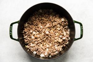 ground beef and onions being cooked in a in a large soup pot