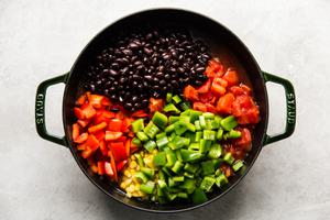 ground beef, onion, green chilies, stock, diced tomatoes, taco seasoning, black beans, corn and bell peppers in a soup pot