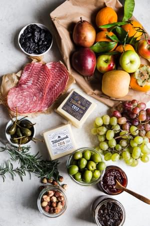 ingredients for the how to build a cheese board salami, nuts grapes