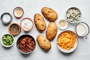 potatoes, cheddar, blue cheese, sour cream, heavy cream, salt, pepper, garlic & onion powder, bacon & green onions in bowls
