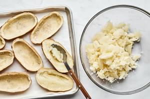 baked potatoes sliced in half with the inside being scooped out