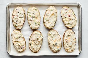 baked potato skins filled with potato mixture made with bacon, cheddar, blue cheese, sour cream, cream, green onion & spices