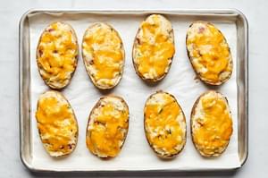 twice baked potatoes on a parchment lined baking sheet