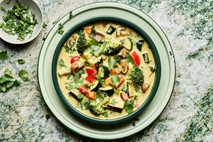a bowl of vegetable curry soup made with onion, celery, carrots, mushrooms, eggplant, broccoli, bell pepper and zucchini