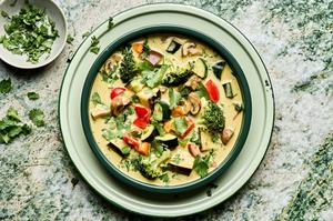 a bowl of vegetable curry soup made with onion, celery, carrots, mushrooms, eggplant, broccoli, bell pepper and zucchini