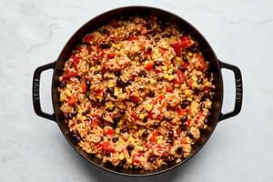 vegetarian stuffed pepper filling cooking in a skillet made with rice, beans, corn, onion and spices