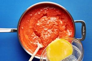 egg & parmesan mixture being poured into a large sauce pan with the other ingredients for vodka sauce carbonara