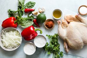 Ingredients laid out for Chicken In Coconut Curry red bell peppers, cilantro, onions, basil, lime, red curry paste and garlic
