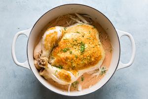 Whole Poached chicken in coconut curry in a soup pot