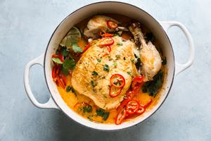 Whole poached chicken in coconut curry with peppers, onions, cilantro and Thai peppers