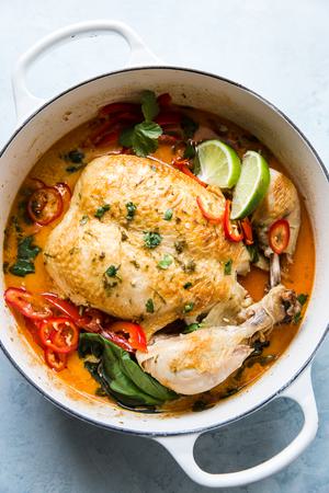 Whole Poached Chicken In Coconut Curry with limes, basil, onions and red bell peppers