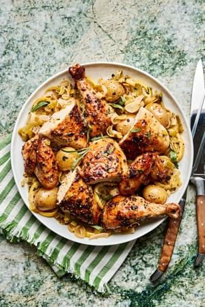 Tender segments of whole roast chicken served alongside crispy potatoes and caramelized leeks, a cozy and delicious dish.