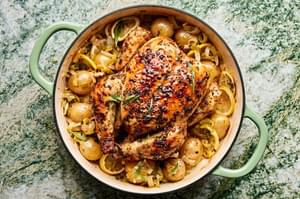 A whole roast chicken paired with crispy potatoes and tender leeks, golden and perfectly roasted for a comforting meal.