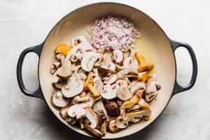 mushroom and shallots being cooked in butter in a skillet