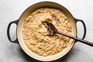 risotto and stock being stirred in a skillet