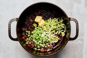 bacon, butter, celery and leeks cooking in a pot to make rich and velvety wild mushroom chowder