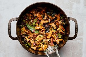 wild mushroom chowder with bacon and leeks being cooked in a pot to make a cozy fall meal