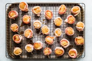 cooling rack lined backing sheet topped with raw bacon wrapped sea scallops