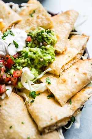 close up of baked chicken quesadillas with guacamole sour cream and pico de gallo