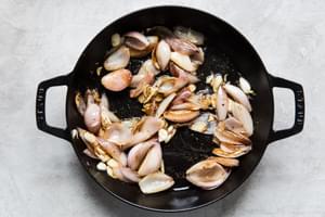 shallots and garlic sautéed in a cast iron skillet.