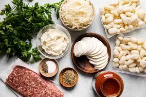 ingredients in small bowls for baked gnocchi with tomato sauce and sausage