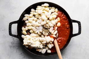 italian sausage, ricotta, marinara sauce, raw gnocchi and spices in a black skillet