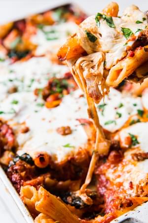 Close up of Baked Penna Alla Vodka With Kale and fresh mozzarella on a serving spoon