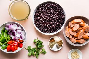 black beans, red onion, bell pepper, chicken stock, spices and smoked sausage in prep bowls to make black bean soup