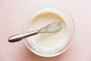 sweet creamy salad dressing in a bowl with a whisk to be used for fresh and crunch broccoli salad