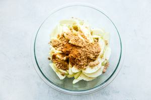 apple slices with cinnamon and brown sugar in a glass bowl