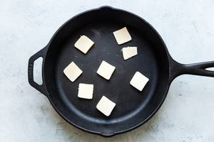 cast iron skillet with piece of butter in it