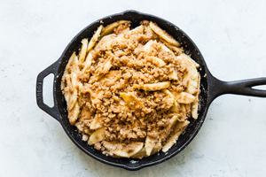 apple slices in a cast iron skillet topped with brown sugar and butter