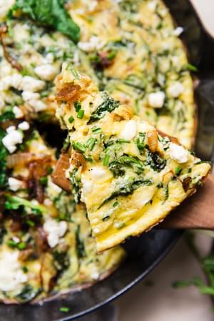 slice of caramelized onion frittata on a wood spatula