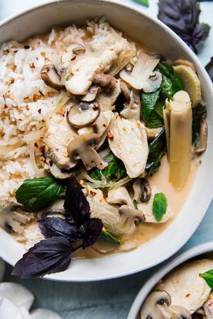 Coconut Chicken Soup Tom Kha Gai in a bowl with basil, mushrooms and lemon grass.