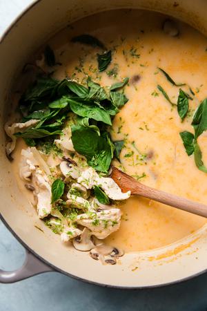 Coconut Chicken Soup Tom Kha Gai in a pot with a wooden spoon