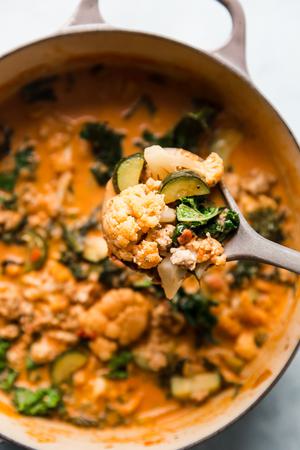 creamy tomato and veggie soup with ground chicken on a ladle