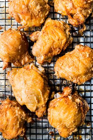 crispy skin-on bone in baked chicken thighs on a baking rack