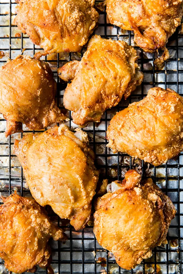 crispy skin-on bone in baked chicken thighs on a baking rack