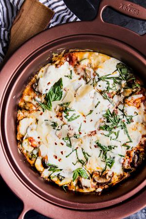 finished vegetarian lasagna in a crockpot with basil and parmesan cheese