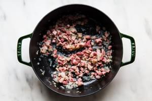 diced pancetta being fried in a pot