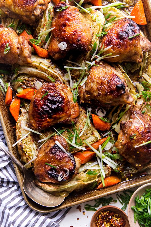 Five Spice Sheet Pan Dinner With Cabbage And Carrots on a baking sheet with a serving spoon