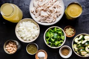 ingredients laid out for green chicken enchilada soup, zucchini, rotisserie chicken, broth, beans