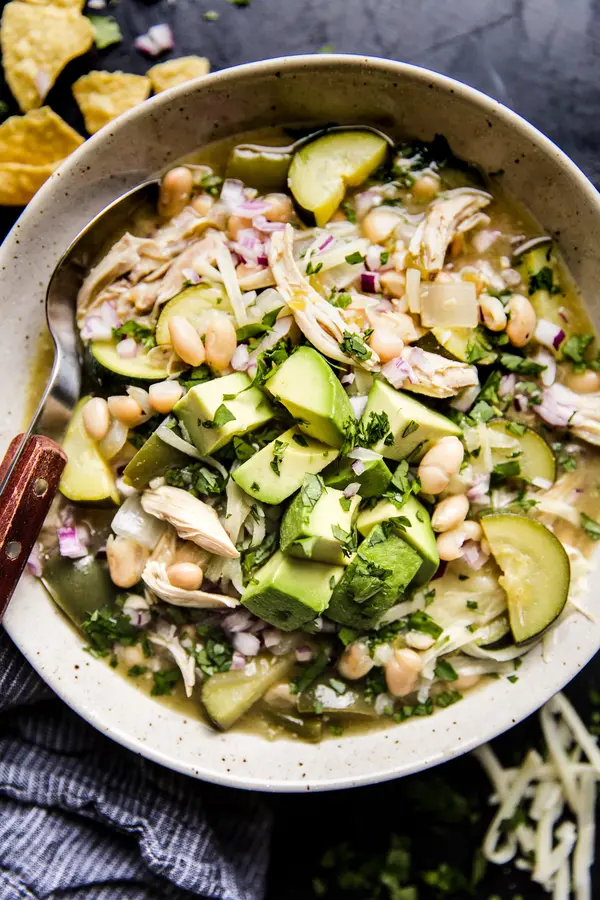 Green Chicken Enchilada Soup recipe with avocado and white beans in a bowl