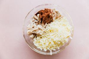 chicken, taco seasoning, and cheese in a bowl