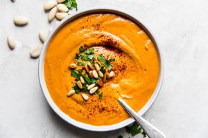 bowl of homemade romesco sauce topped with pine nuts, parsley and smoked paprika