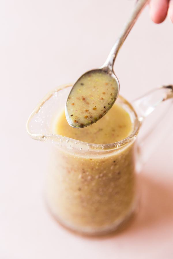 Honey Mustard Salad Dressing in a small pitcher with a spoon